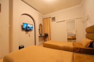 a hotel room with two beds and a flat screen tv at Al Barra Syariah Hotel in Bukittinggi