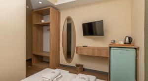 a room with a bed and a tv and a mirror at The Mint Urla in Kuscular