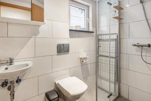 a white bathroom with a toilet and a sink at Jolie Appartement Bei Kassel in Eiterhagen