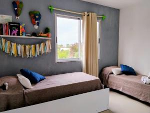 a bedroom with two beds and a window at YellowStone in Balneario Buenos Aires +46 photos