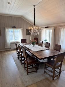 a dining room table with chairs and a chandelier at Finnegården Røros in Røros +29 photos