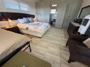 a bedroom with a bed and a couch and a chair at Karibu Self-Catering Unit 1 in Omaruru