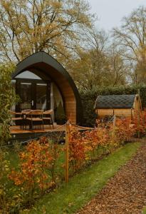 a tent in a garden with a table and a building at luxury cottage with sauna in Milsbeek