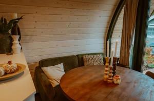 a wooden table and chairs in a room with a table and a table at luxury cottage with sauna in Milsbeek