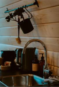 a kitchen sink with a pot hanging from a kitchen faucet at luxury cottage with sauna in Milsbeek