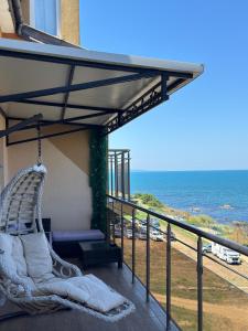 a hammock on a balcony with a view of the ocean at Апартаменти Генезис Ахтопол in Ahtopol