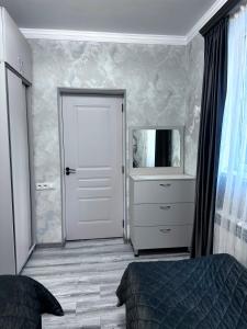 a bedroom with a door and a dresser and a mirror at Jermuk Cozy Apartment in Jermuk