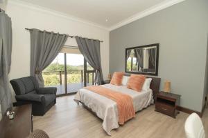 a bedroom with a bed and a chair and a window at Bevuline in Gqeberha +21 photos