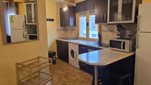 a kitchen with a refrigerator and a counter with a microwave at La Ribera in Arroyo Frio