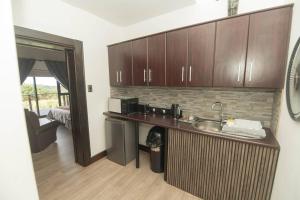 a kitchen with a sink and a counter with a microwave at Bevuline in Gqeberha