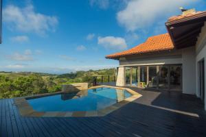 a house with a swimming pool on a wooden deck at Bevuline in Gqeberha