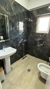 a bathroom with a sink and a toilet at Laska's Rooms Sarandë in Sarandë +13 photos