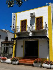 a yellow and white building with a sign on it at Albergo Villamarina in Santa Teresa Gallura