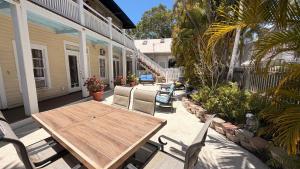 an outdoor patio with a wooden table and chairs at The Independent Inn in Key West
