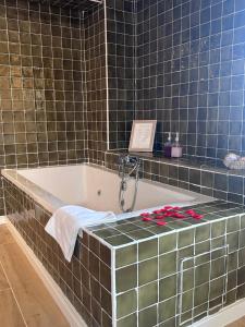 une salle de bains avec une baignoire ornée de fleurs rouges dans l'établissement Mas els Munts, à Vilanova de Sau