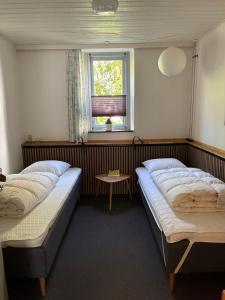 two beds in a room with a window at Ibsens Gaard in Ebeltoft