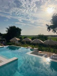 a swimming pool with umbrellas and a view of the countryside at Quinta Amala in Melides