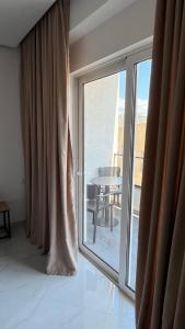 a room with a large window with a view of a table at Laska's Rooms Sarandë in Sarandë