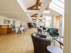 a dining room with tables and chairs and windows at Plas Dolguog in Machynlleth