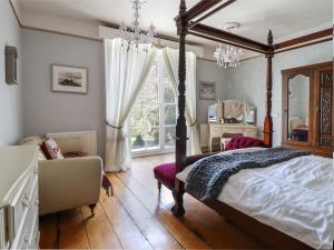a bedroom with a canopy bed and a window at Plas Dolguog in Machynlleth