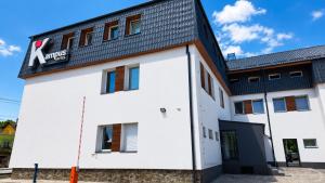 a white building with a black roof at Kampus Hotel Poruba in Ostrava