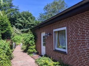 ein Backsteinhaus mit einer weißen Tür und einem Fenster in der Unterkunft Renova13 in Süderbrarup