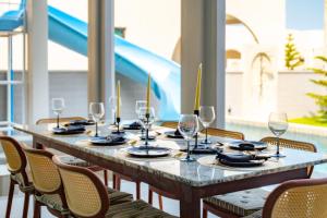 a long table with wine glasses and a blue slide at April Pool Day Villa Cha-am in Cha Am