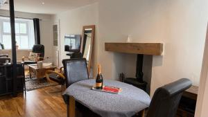 a living room with a table with a bottle of wine on it at The Burrow in Kendal
