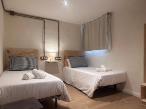 une chambre avec deux lits avec des serviettes dessus dans l'établissement Mas els Munts, à Vilanova de Sau