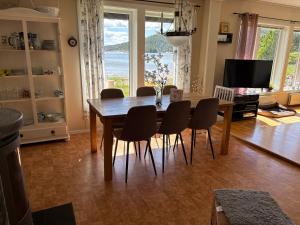 a dining room with a table and chairs and a television at Höga kusten Berghamn in Noraström