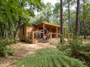 a man on a bike in front of a tiny house at La forêt PALOMA, Ecolodge in Léon