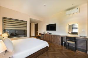 a hotel room with a bed and a flat screen tv at Khách sạn Neva in Long An