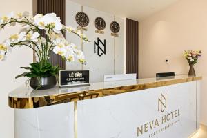a reception desk with a vase of flowers on it at Khách sạn Neva in Long An