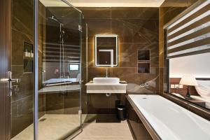 a bathroom with a tub and a sink and a shower at Khách sạn Neva in Long An