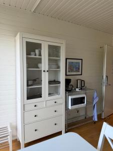 a white cabinet in a room with a microwave at KSSS Vandrarhem Telegrafholmen in Sandhamn
