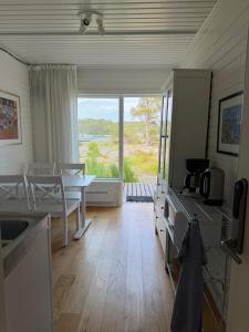 a living room with a table and a kitchen with a view at KSSS Vandrarhem Telegrafholmen in Sandhamn