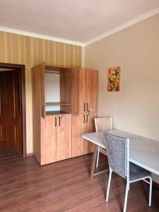 a dining room with a table and a cabinet at Safari Stop Hostel in Almaty