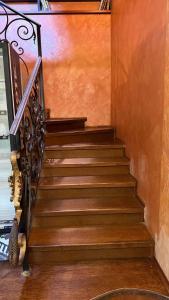 a staircase in a house with wooden floors and a railing at Safari Stop Hostel in Almaty