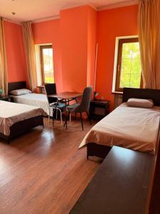 a bedroom with two beds and a table and chairs at Safari Stop Hostel in Almaty