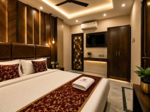 a bedroom with a large bed and a television at Orbit guest house by Flying Suites in Kolkata +6 photos