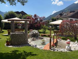 a garden with a bench and an umbrella at Hotel Miramonti in Pinzolo +20 photos