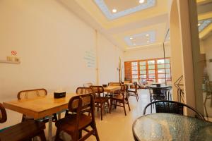 a dining room with wooden tables and chairs at Al Barra Syariah Hotel in Bukittinggi