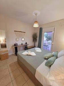 a bedroom with a large bed with towels on it at Mylo Casa Karfas in Chios
