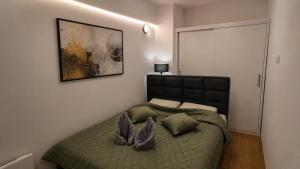 a bedroom with a green bed with two pillows at Urban Center Paraćin in Paraćin