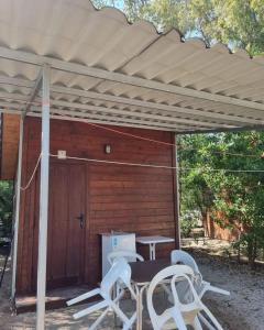 a wooden shed with a table and chairs under a pergola at Camping la Naranja in Gandía