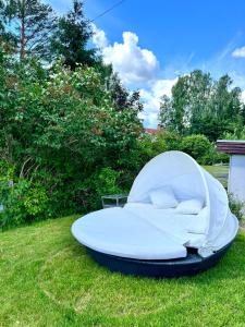 a white bed in the grass in a yard at Nordic Quiet Stay in Falun