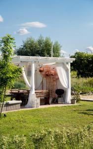 a white gazebo with a table and a chair at Coco Beach Cupel - Domek AQUA z jakuzzi in Cupel +50 photos