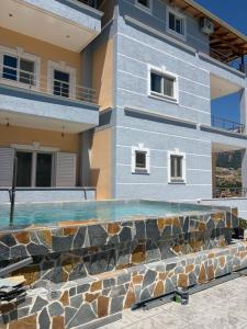 a house with a swimming pool in front of a building at Villa Xani in Himare