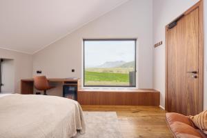 a bedroom with a bed and a large window at Tindasel - The Farm in Hella
