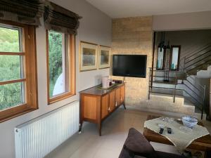 a living room with a flat screen tv on a wall at Elis superb house in Psathíon